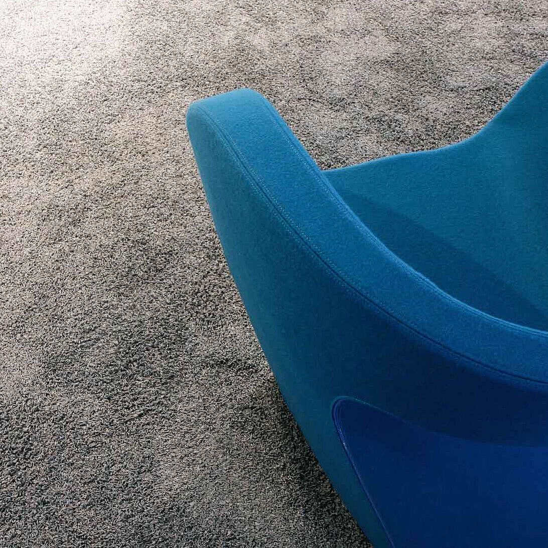 Blauer Couch-Sessel auf grauem Teppich